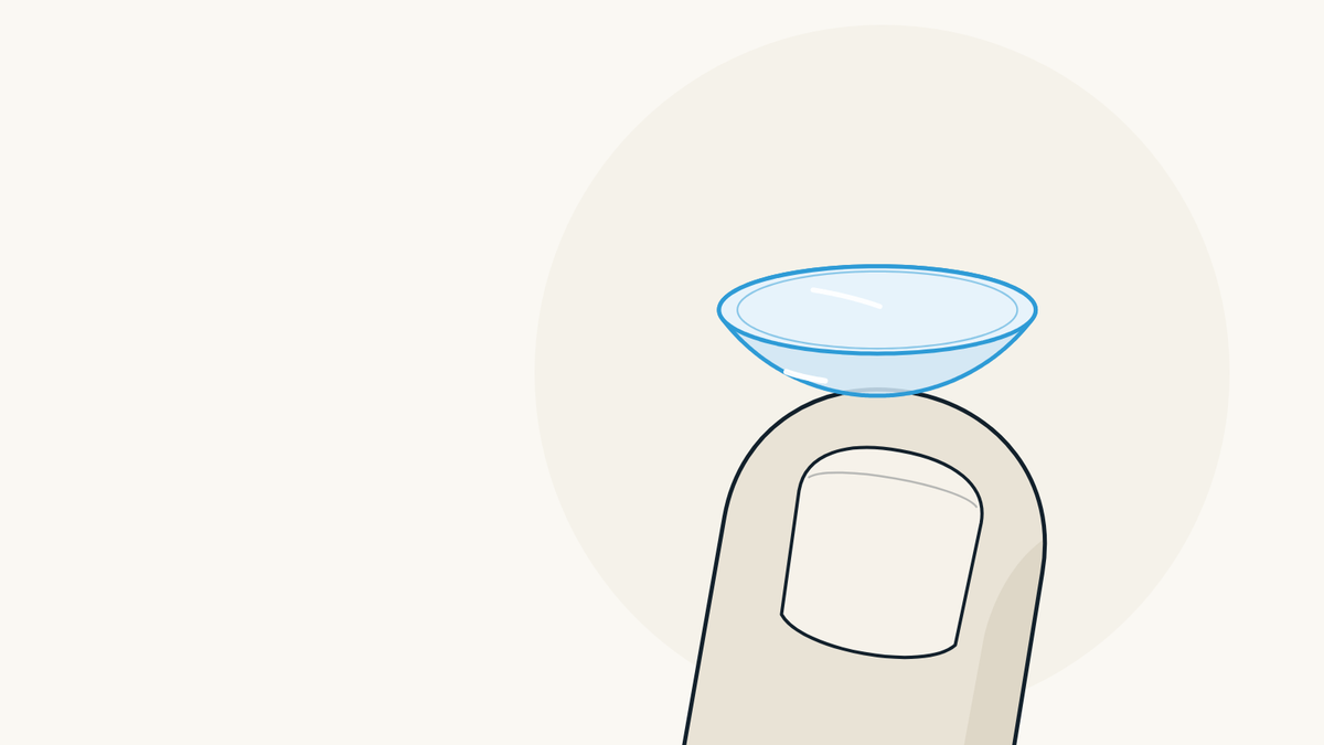 Illustration of a soft contact lens resting on a fingertip, right side out, shaped like a small bowl.